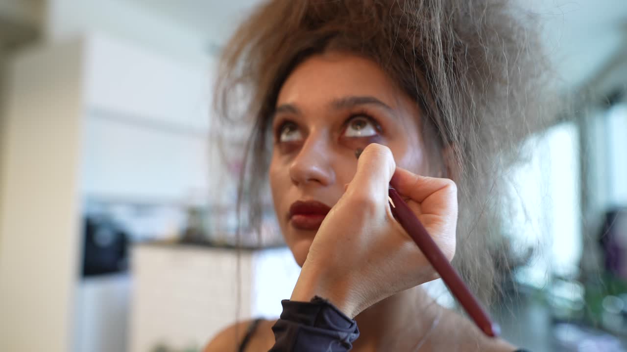 Makeup Artist Applying Eyeshadow to Young Woman's Face