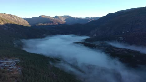 Morgendlicher-Nebel-Füllt-Den-Boden-Des-Eksingedalen-tals-In-Norwegen-Während-Des-Sonnenaufgangs-Am-Frühen-Morgen-Zwischen-Bergen---Aufwärts-Bewegende-Luft-In-Wildnislandschaft-Und-Wald