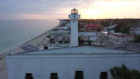 low aerial push in at sunrise towards the lighthouse in telchac puerto in yucatan, mexico