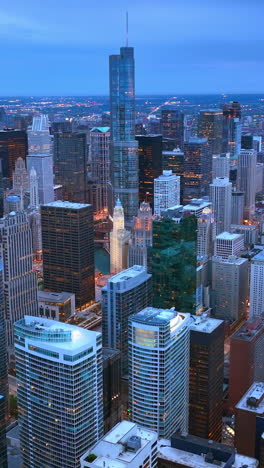 breath-taking view of marvelous chicago skyscrapers at dusk time. amazing city panorama with lights in the evening. aerial view. vertical video
