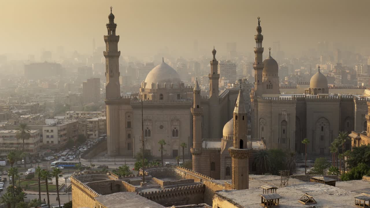fotografía panorámica de la mezquita del sultán hassan, el cairo, egipto al atardecer. la ciudad de el cairo en una niebla ligera en los rayos del sol poniente. fotografía de alta calidad en 4k