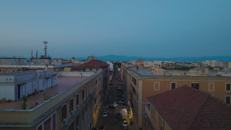 Rooftop-view-of-buildings-in-residential-urban-borough-at-dusk.-Forwards-fly-above-street.-Rome,-Italy