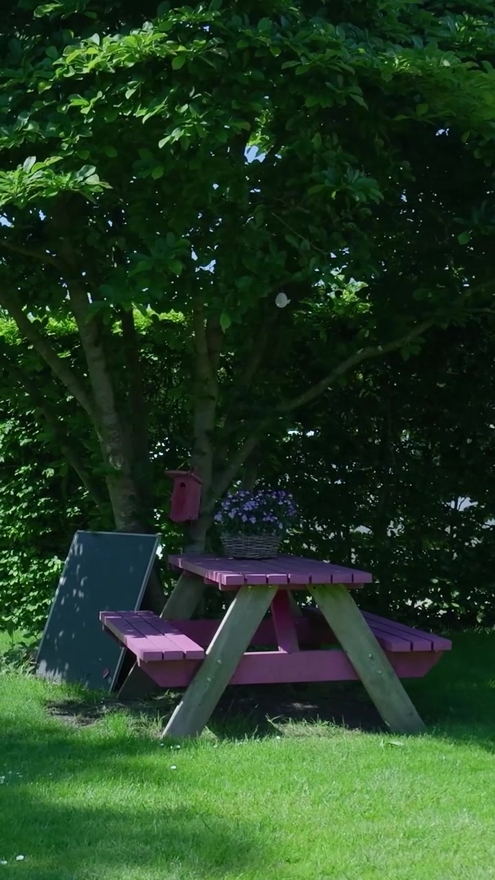 Pink Picnic Table Under a Tree in a Lush Green Garden