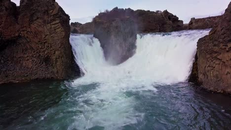 Two-waterfalls-from-the-same-river-gush-into-blue-pond-in-Iceland