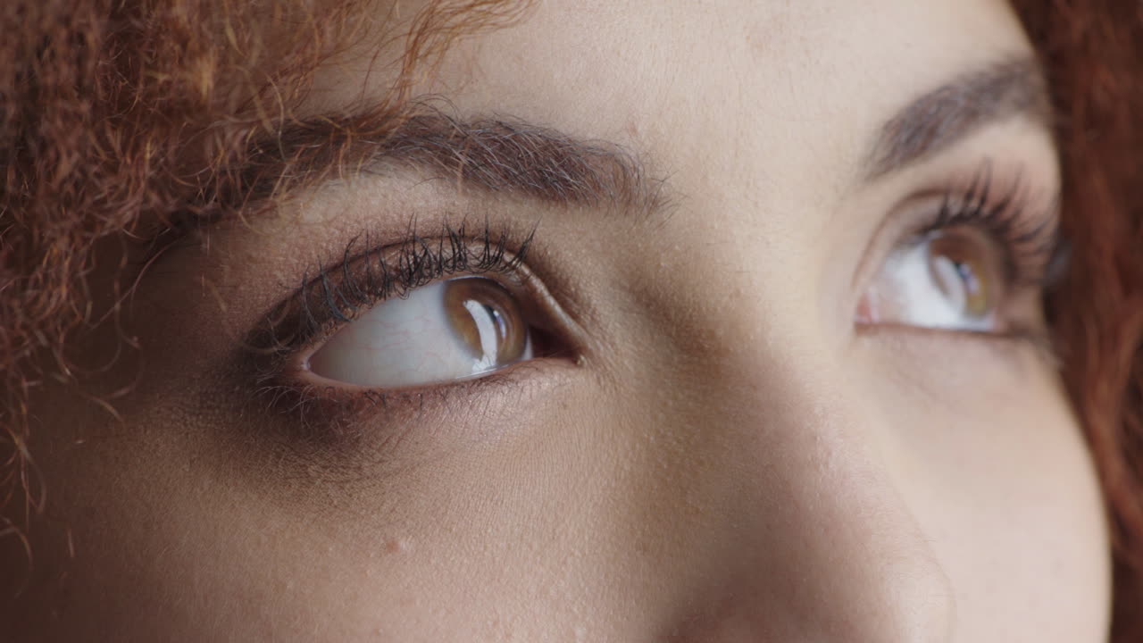 가까이서 아름다운 젊은 여성의 눈이 머릿속을 들여다보며  ⁇ 상하고 화장을 하고 있습니다.