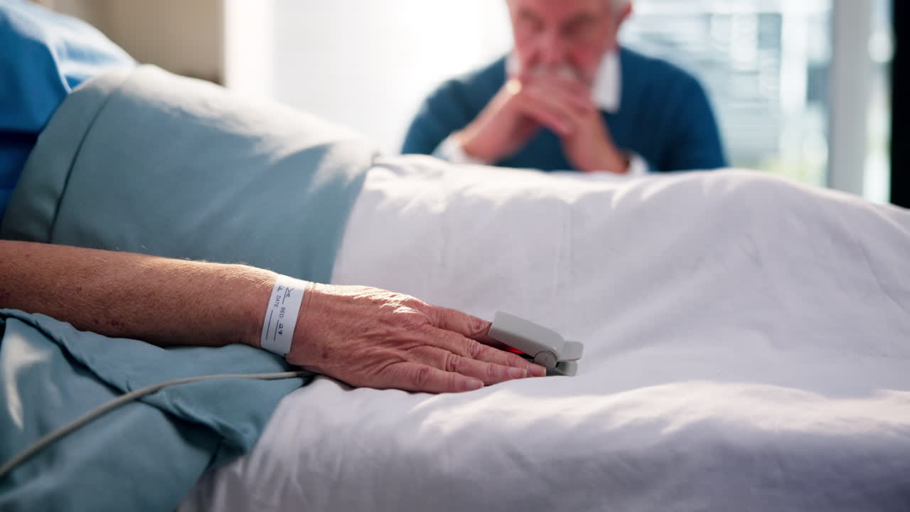 Senior Patient in Hospital Bed with Concerned Visitor