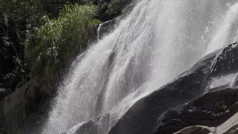 cascada en cámara lenta sobre la pared de la superficie rocosa
