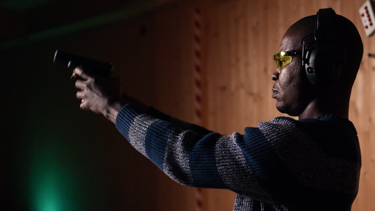 Portrait of happy shooting range customer reloading pistol, close up