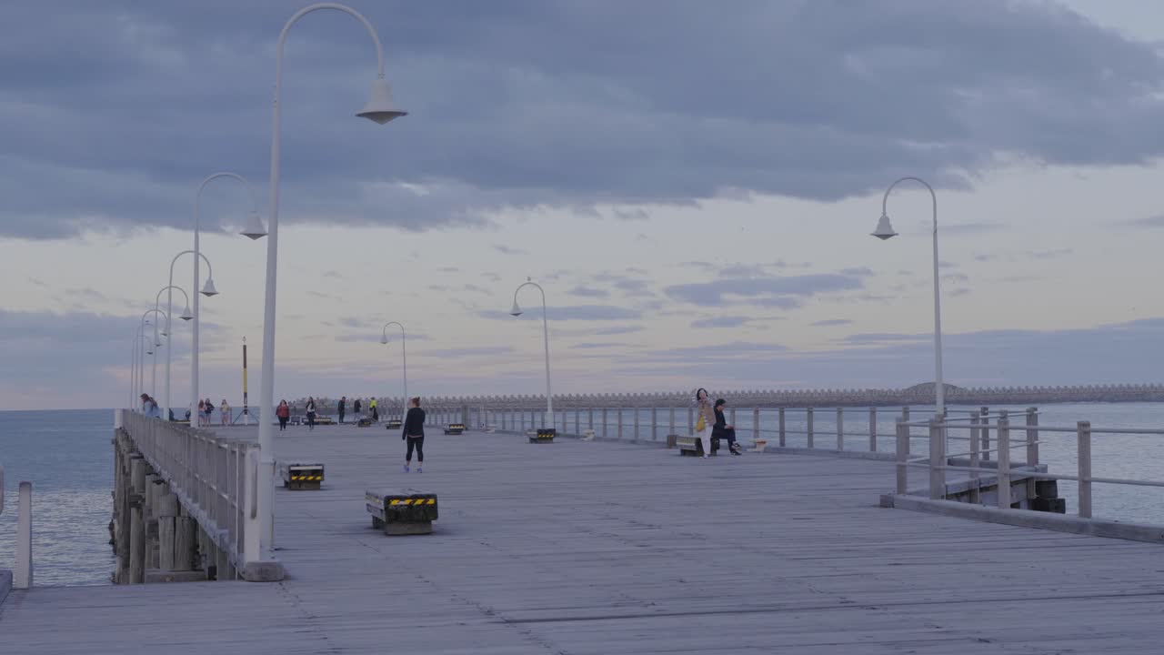 una dama tomando selfie en el embarcadero del puerto de coffs en nsw, australia - destino de vacaciones perfecto - plano general