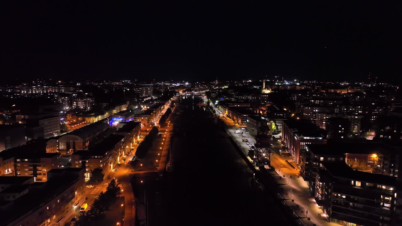Drone flying backwards over the Aura river, night in Turku city, Proper Finland