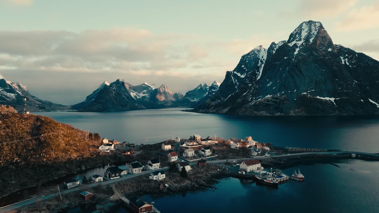 Fishing Village With Rocky Mountains In The Background At Reine In Moskenes Municipality, Nordland County, Norway. Aerial Shot