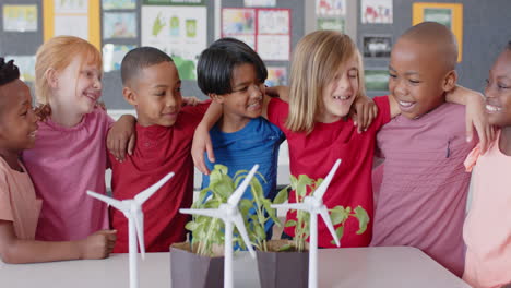 in school, diverse group of children smiling and hugging near wind turbines