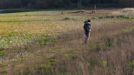 Fotograf-Mit-Stativ-Und-Kamera-Zu-Fuß-Auf-Dem-Land