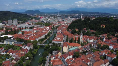 4k cinematic drone aerial view of ljubljana old town and ljubljana castle with mountains in the background