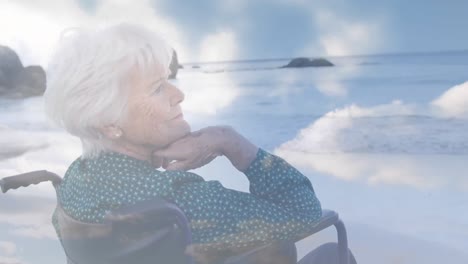 animation of glowing light over senior woman in wheelchair by seaside