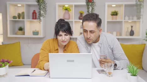 couple shopping online on laptop. happy and fun.