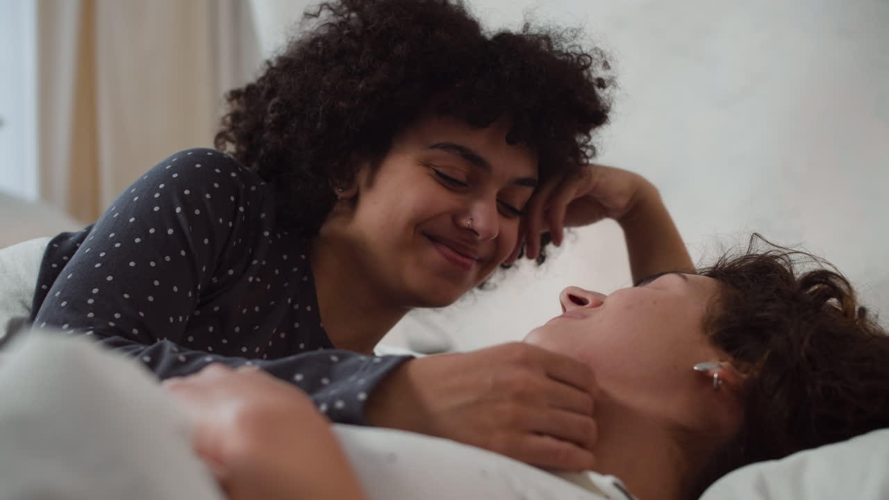 una pareja feliz hablando en la cama.