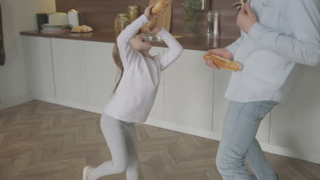 Papá-E-Hija-Cantan,-Bailan-Y-Juegan-Con-Comida-En-Casa.