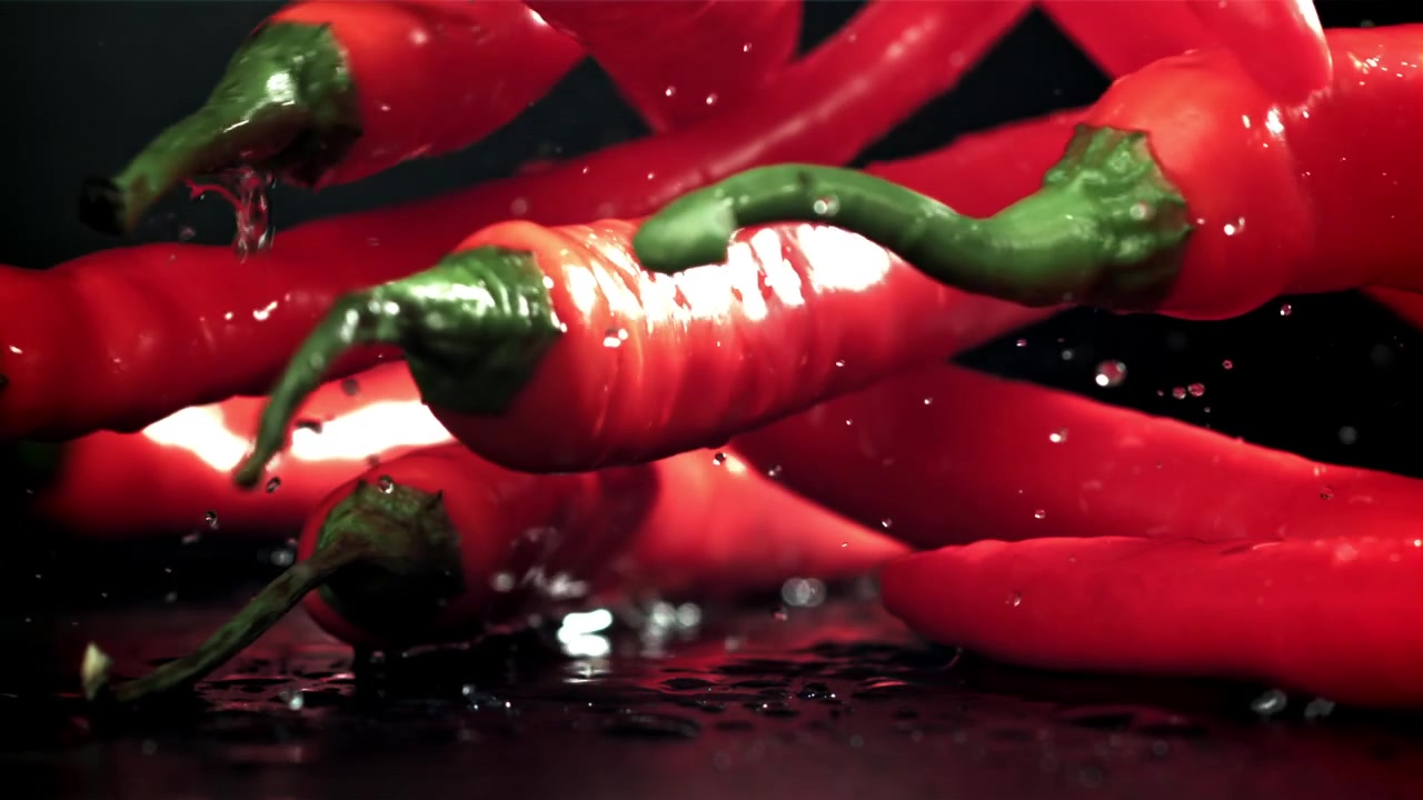 Red Chili Peppers Falling and Splashing in Slow Motion