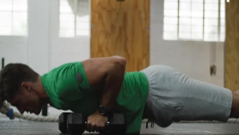 Side-view-athletic-Caucasian-man-lifting-alternate-weights