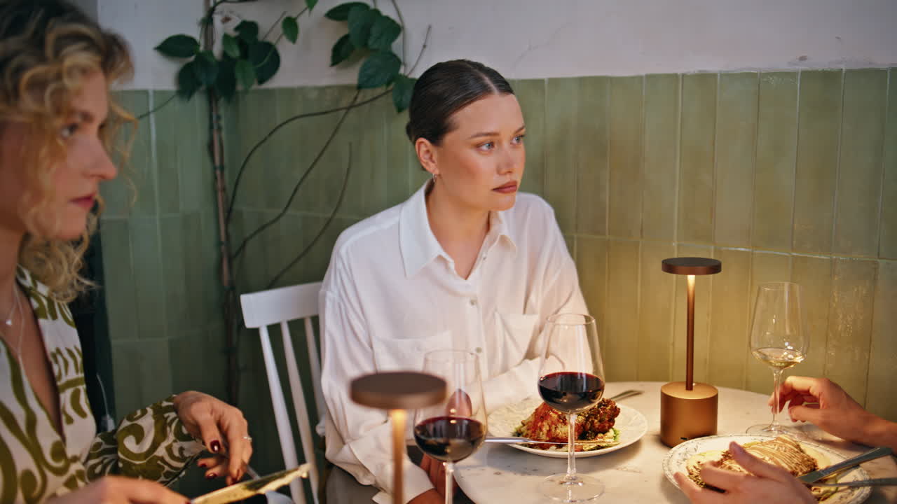 Serious girls discussing gossip dining together at luxury restaurant closeup