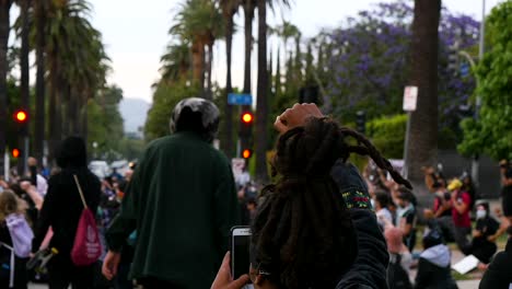 protesters hold up fists and listen to speaker during a black lives matter blm march in los angeles following the george floyd murder 1