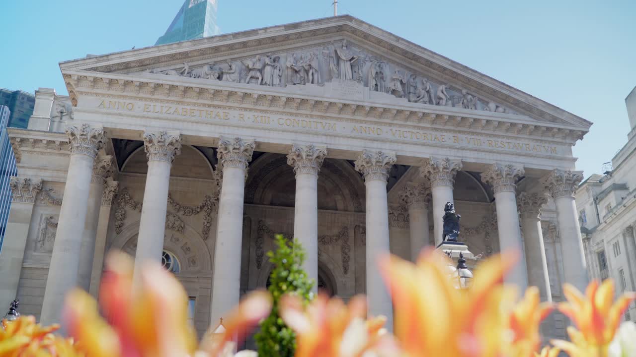 Beautiful view of Royal Exchange London building from the tulip garden in front in a clear sunny day