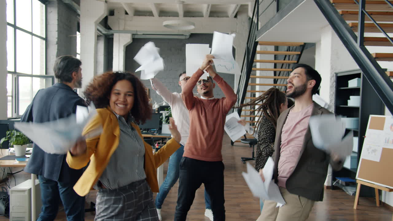 Team d'ufficio felice che celebra il successo con un lancio di carta