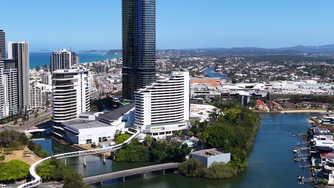 Daytime drone footage glides above river, high-rise buildings, bridges, and urban landscape in Australia