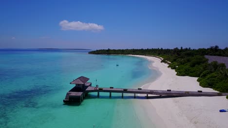 aerial pullback from wooden jetty on hanimaadhoo island in the maldives 4k