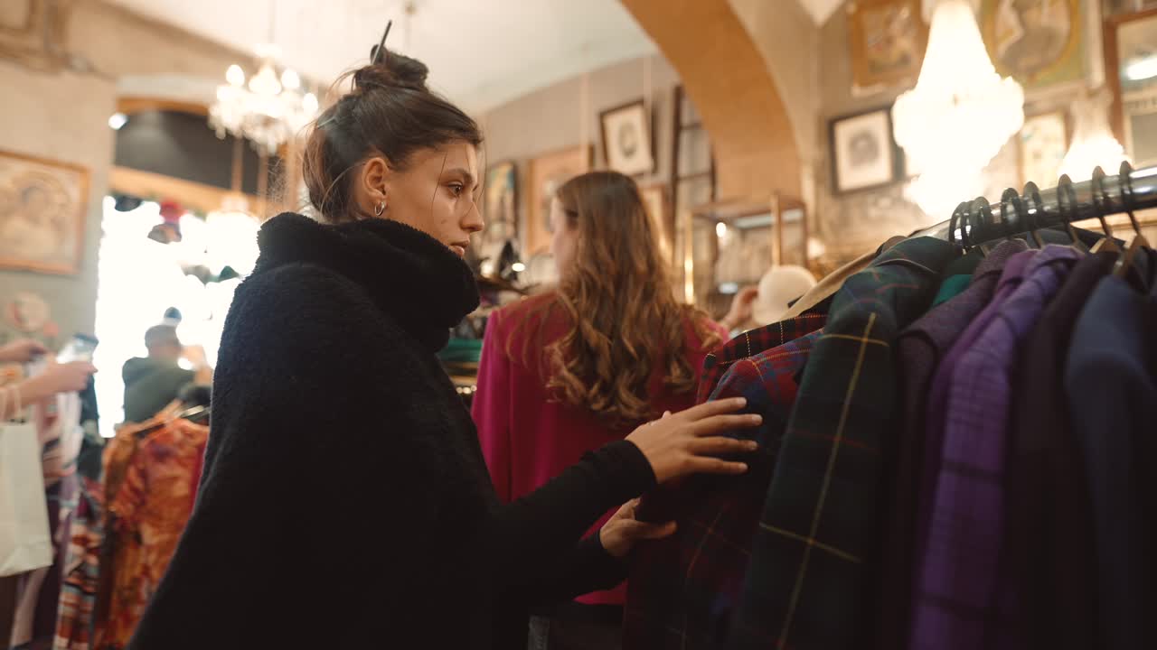 한 여자 가 빈티지 가게 에서 옷 을 구입 하고 있다