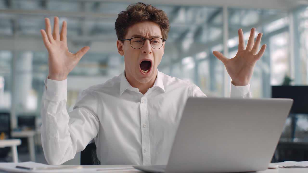 A Dramatic Transformation: A Young Man Exhibits a Range of Emotions from Frustration to Joy While Interacting with His Laptop in a Modern Office Setting