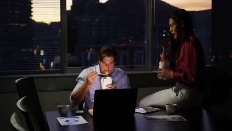 front view of young caucasian office executives eating food at desk in modern office 4k