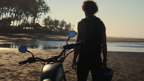 man on motorcycle at beach sunset