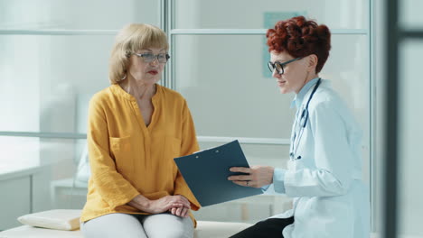 mujer anciana y doctora hablando en el sofá médico en la clínica