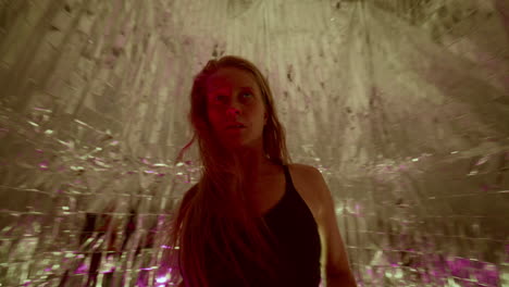 female dancer performing fluid, expressive movements under colorful lights