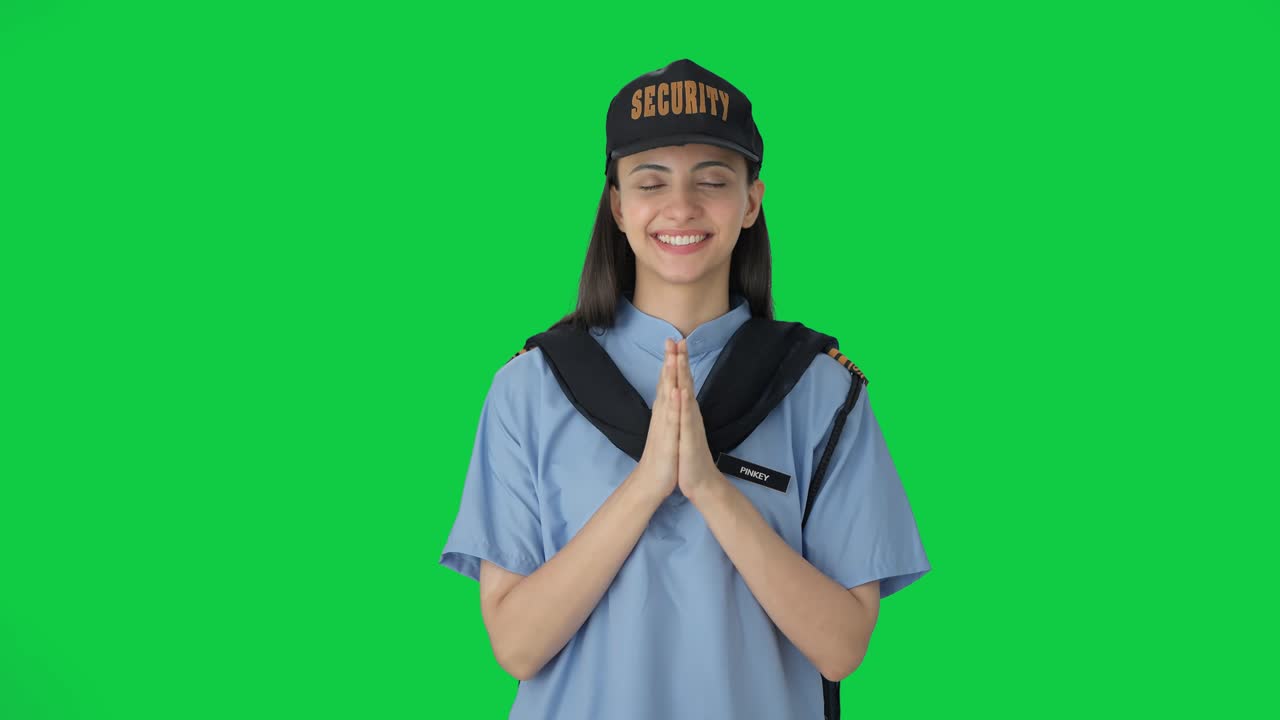 Guardia di sicurezza indiana felice che fa Namaste. Schermo verde
