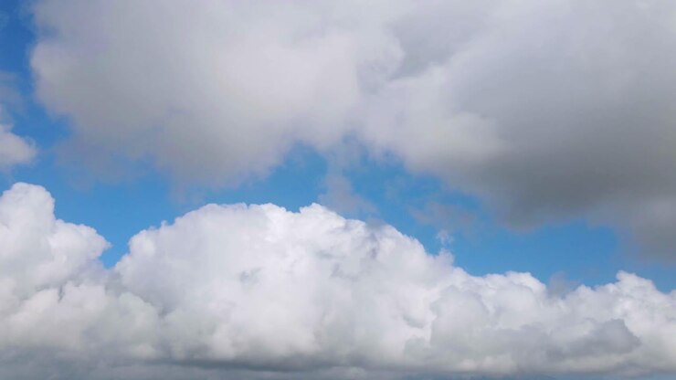 Hyperlapse shot of flying clouds against blue sky in the air - view from airplane