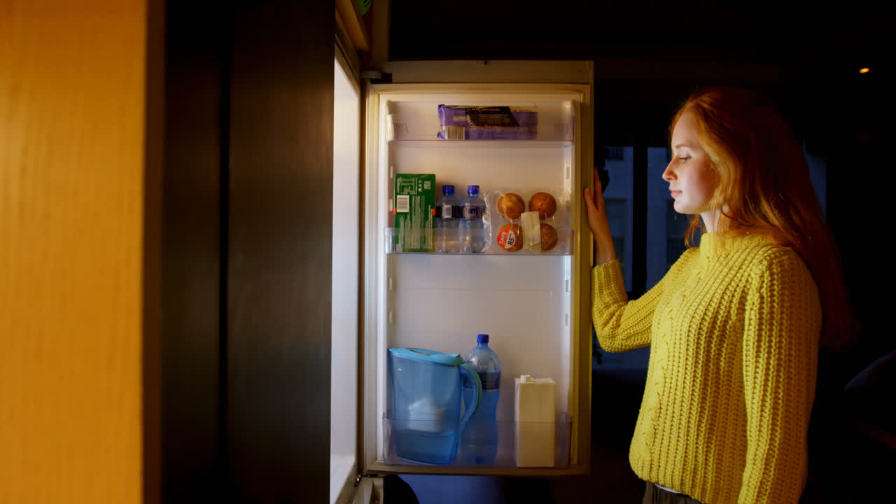 Woman Opening Refrigerator Door In Kitchen K Premium Stock Video Footage