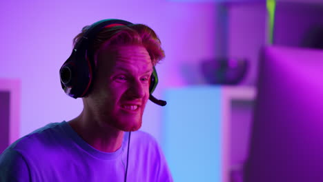 smiling gamer enjoying cyber match victory closeup. cheerful guy talking headset