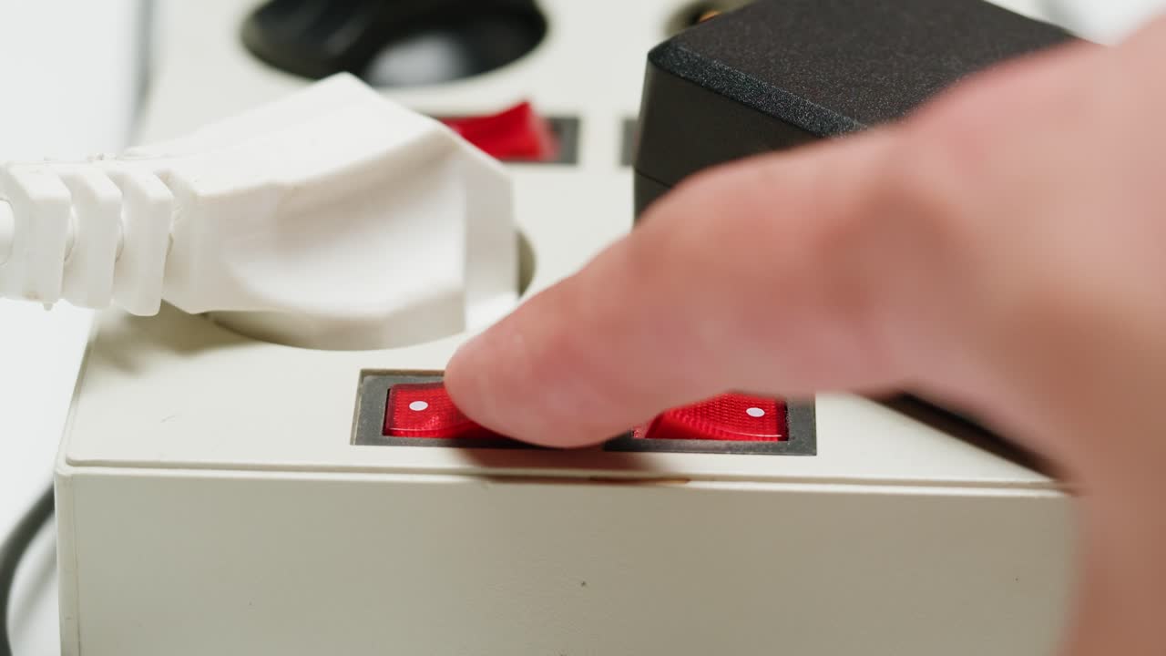 White power strip with many various of cords and cables in close-up. An extension cord with many power sockets. Adapter with phone, headphones, usb connectors.Tangled wires on table. Trying to untangle many messy cables.