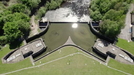 overflow valve-houses of ladybower reservoir in hope valley, united kingdom with sun reflection on calm water