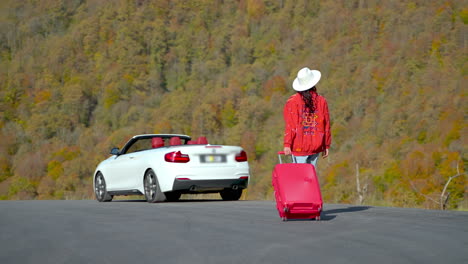 mujer con maleta en un viaje por carretera