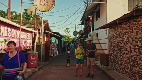 tourists walking through a narrow street in a costa rican town