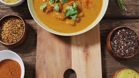 video of freshly prepared curry in bowl lying on board on wooden surface