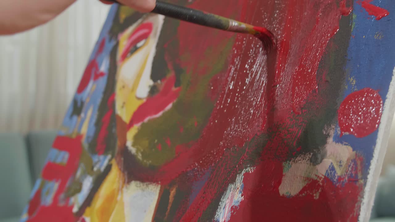 cerca de una niña de una mano sosteniendo un pincel y pintando la cara de una niño en el lienzo