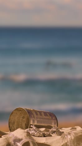 vertical video of pollution concept with hand picking up litter and rubbish on beach against sea background