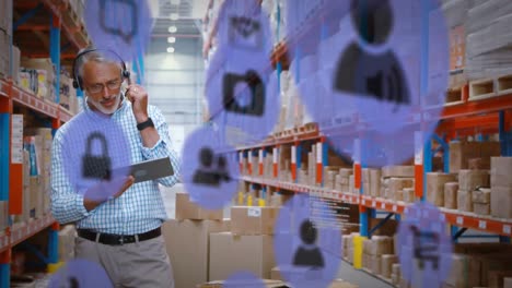 animation of caucasian man checking stock in warehouse area man over blue icons