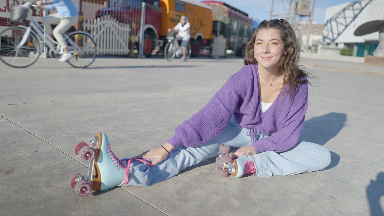 Young Woman in Purple Sweater Stretching with Roller Skates