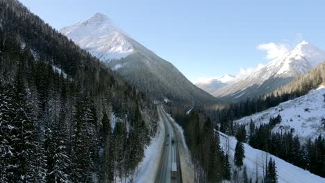 viaje invernal por la carretera transcanadiense 1: automóviles y camiones rodeados de impresionantes montañas en columbia británica, canadá